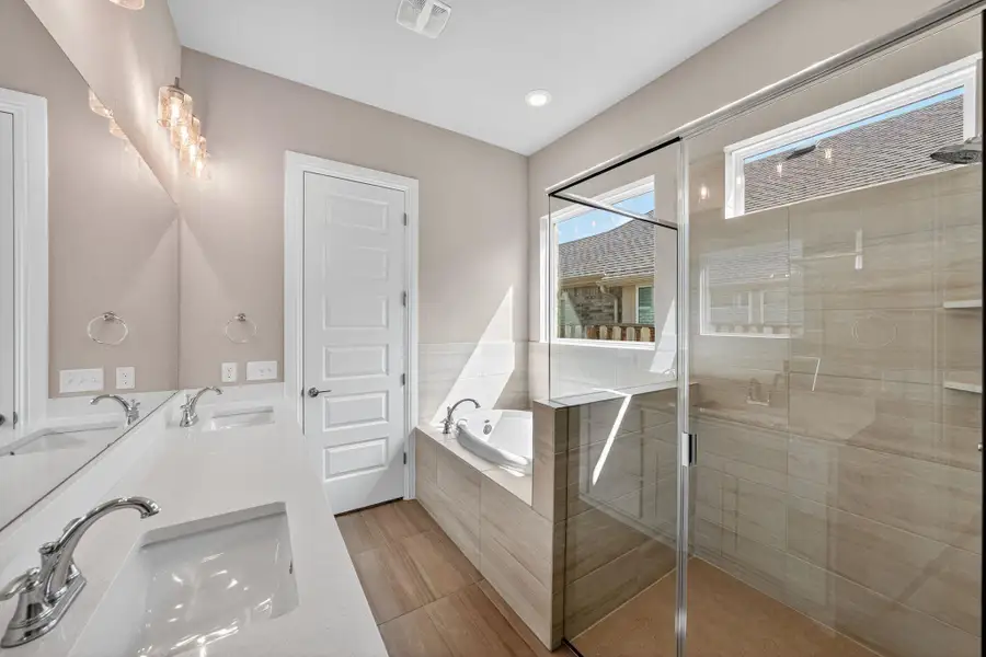 Full bath featuring a bath, double vanity, a shower stall, and recessed lighting Full bath featuring a bath, double vanity, a shower stall, and recessed lighting