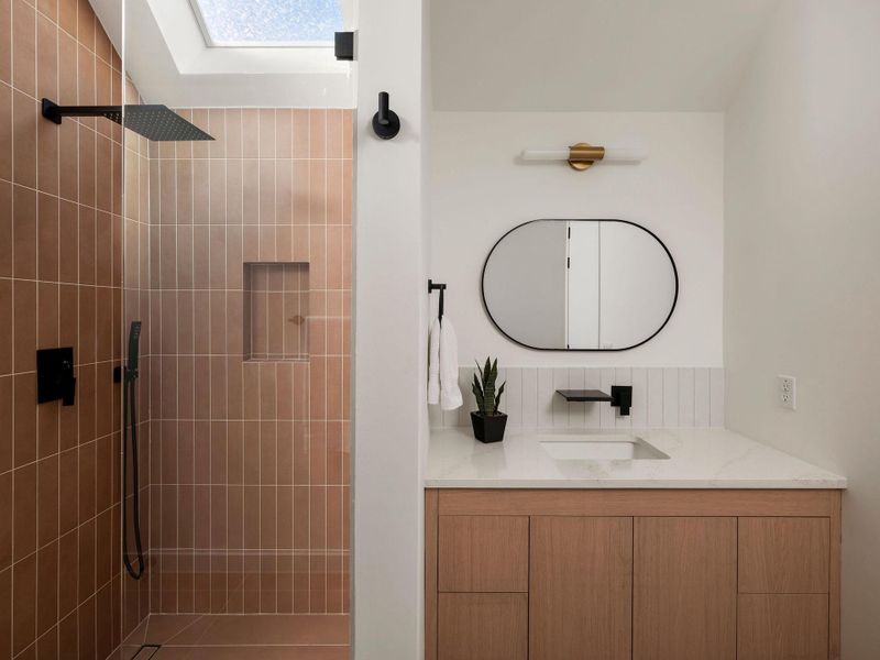 Full bathroom featuring a tile shower and vanity