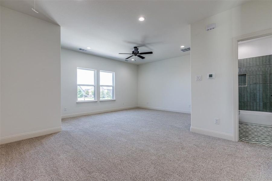 Spare room featuring light carpet and ceiling fan