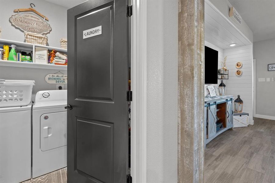 Laundry room featuring washer and dryer and light wood-type flooring