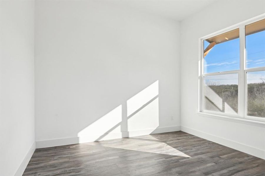 Empty room featuring wood finished floors and baseboards