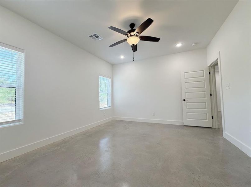 Spare room featuring concrete flooring, ceiling fan, and recessed lighting Spare room featuring concrete flooring, ceiling fan, and recessed lighting
