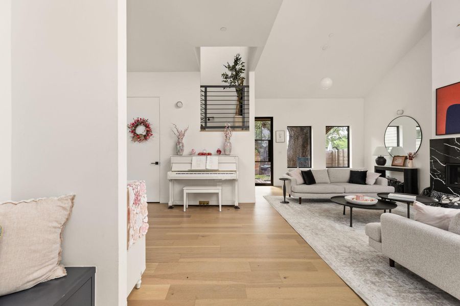 Vast living area with a fireplace, featuring soaring vaulted ceilings and rich hardwood flooring throughout. Vast living area with a fireplace, featuring soaring vaulted ceilings and rich hardwood flooring throughout.