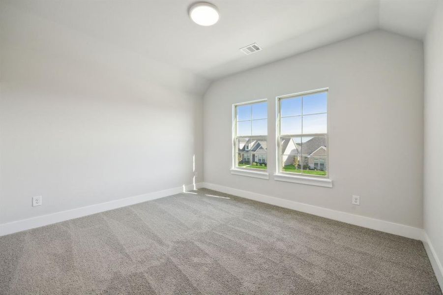 Carpeted spare room with lofted ceiling