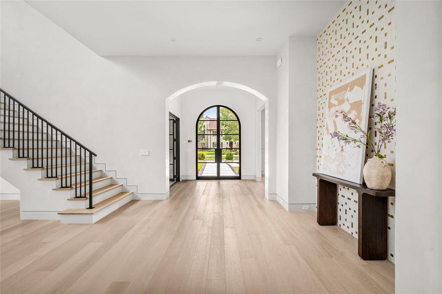 Stepping into the welcoming foyer, you are greeted by impeccable, custom imported gold tile. White oak wood floors spread seamlessly throughout the first floor, offering effortless, timeless elegance.