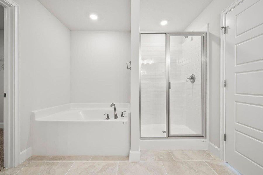 Master Bathroom Featuring Roman Tub and Shower Glass Door