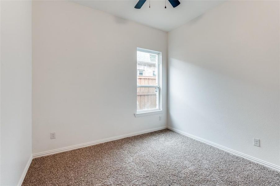 Unfurnished room featuring ceiling fan and carpet