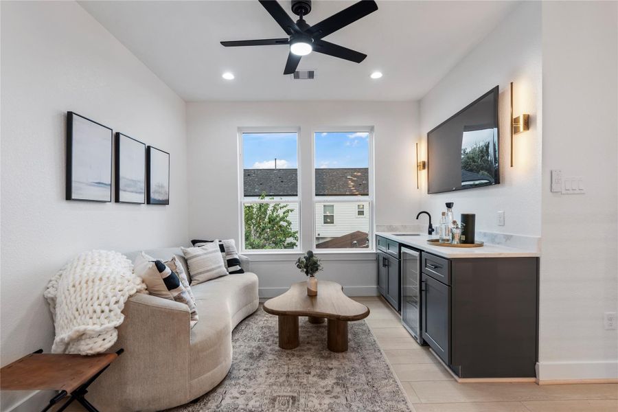 Upstairs game room with wet bar, wine fridge, and oversized windows. Upstairs game room with wet bar, wine fridge, and oversized windows.