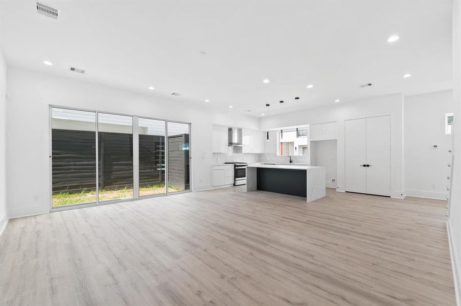 Ample natural light from large sliding doors and recessed lighting throughout. The space has a fresh, clean color palette, ready for personalization.