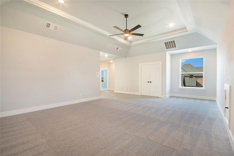 Carpeted empty room featuring a tray ceiling, recessed lighting, ceiling fan, and ornamental molding Carpeted empty room featuring a tray ceiling, recessed lighting, ceiling fan, and ornamental molding
