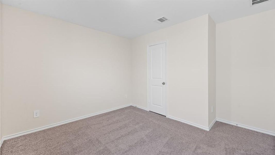 Carpeted room with a white paneled door, light neutral wall paint, and white baseboards Carpeted room with a white paneled door, light neutral wall paint, and white baseboards