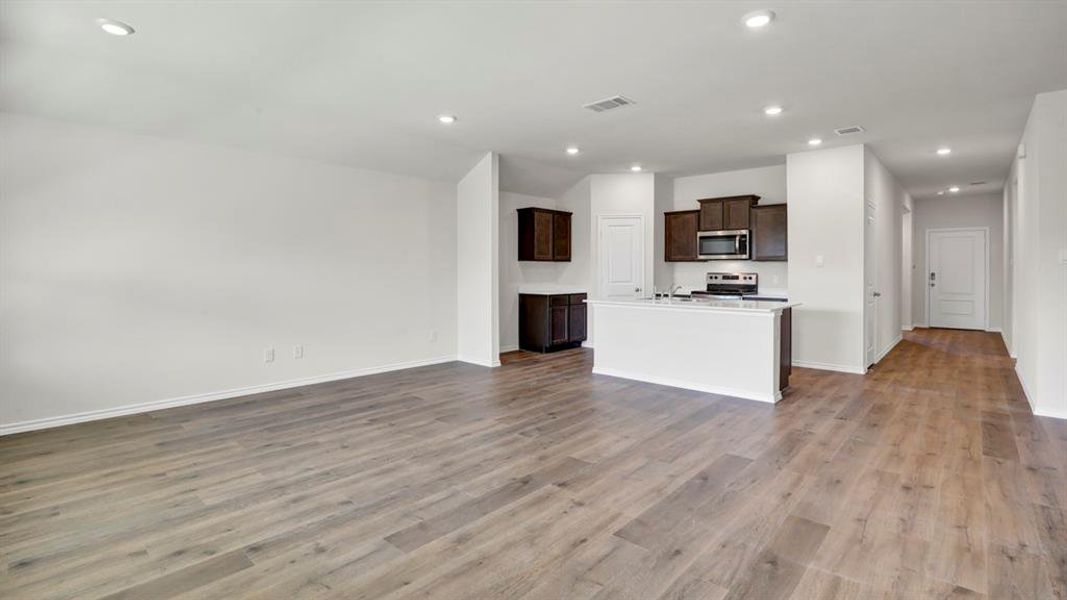 Spacious living area featuring wood-finish flooring and recessed lighting