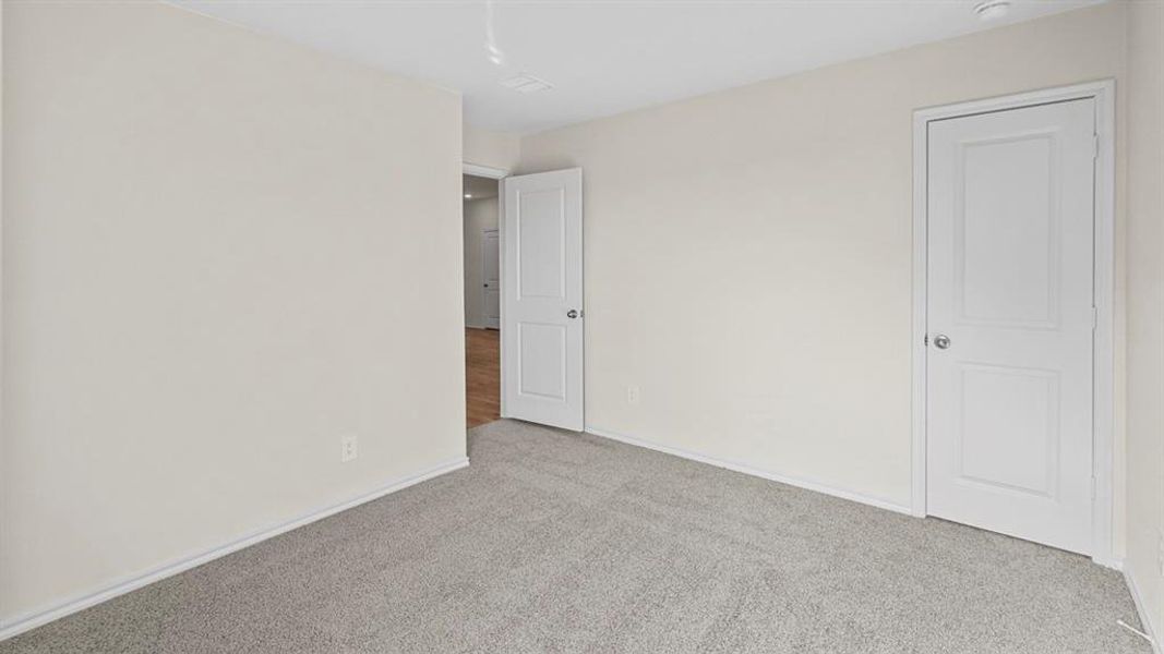 Unfurnished bedroom featuring light colored carpet and baseboards