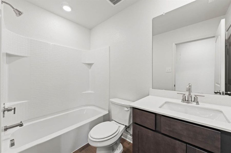 Full bathroom featuring wood-style flooring, vanity, toilet, and shower / bath combination