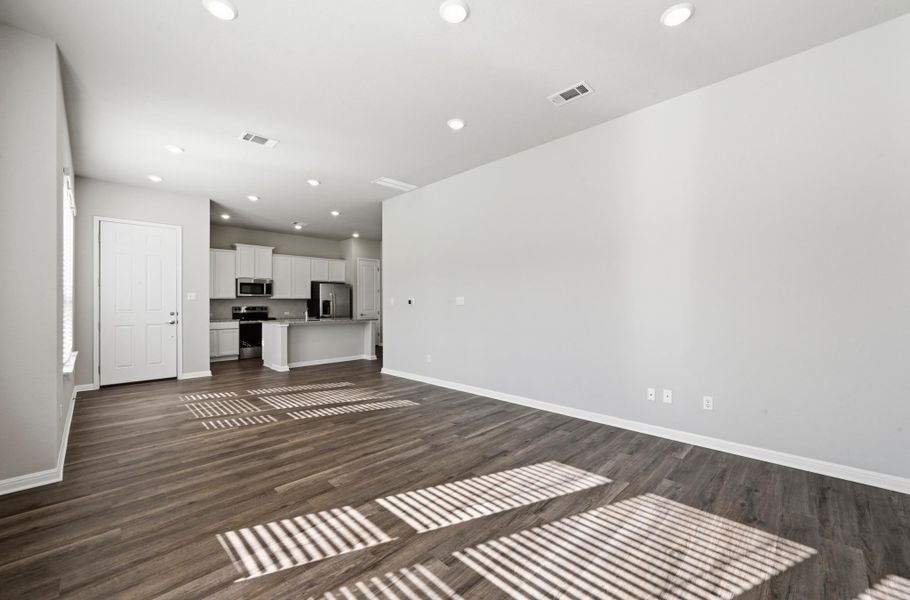 Open-concept living space featuring wood-finish flooring, recessed lighting, and a neutral wall palette Open-concept living space featuring wood-finish flooring, recessed lighting, and a neutral wall palette