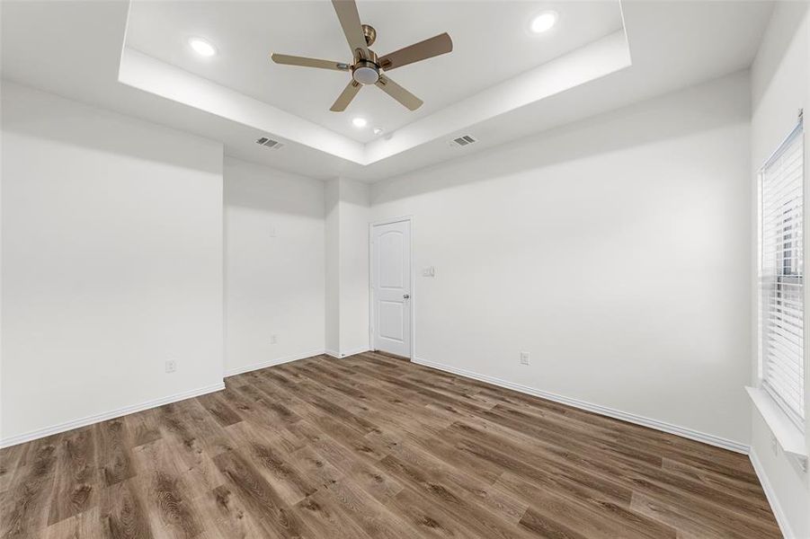 Empty room featuring a raised ceiling and hardwood / wood-style floors