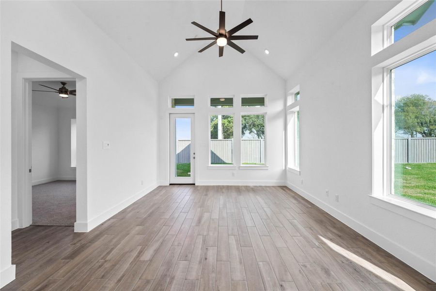 A grand great room with tall ceilings, ceiling fan, abundant natural light, and an open, inviting ambiance--perfect for gatherings, relaxation, and making memories.
