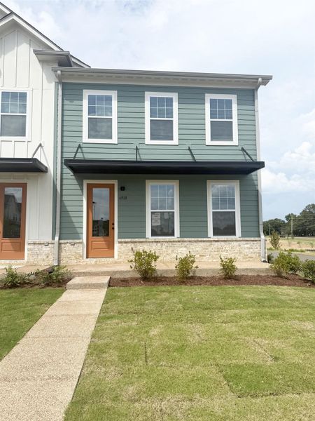 View of front of home with a front yard and board and batten siding