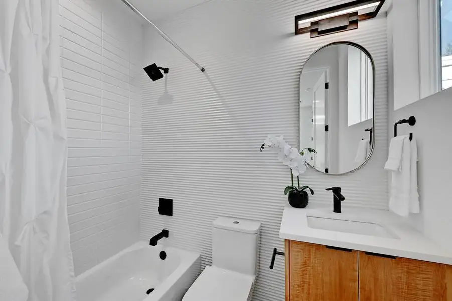 Bathroom with shower / bath combo, vanity, and toilet