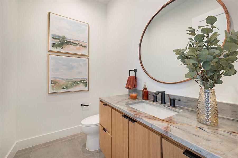 Bathroom featuring toilet, vanity, and tile patterned floors