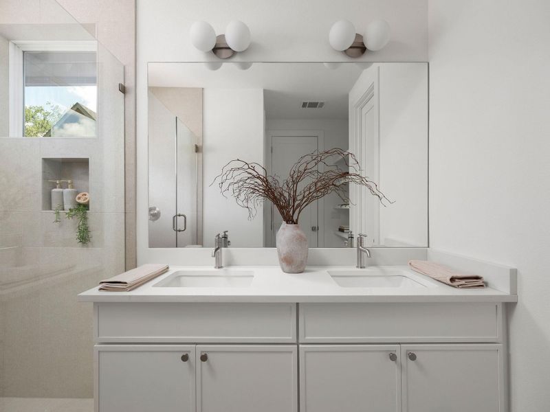 A sleek vanity with dual sinks, modern lighting, and a spacious mirror creates a functional bathroom.