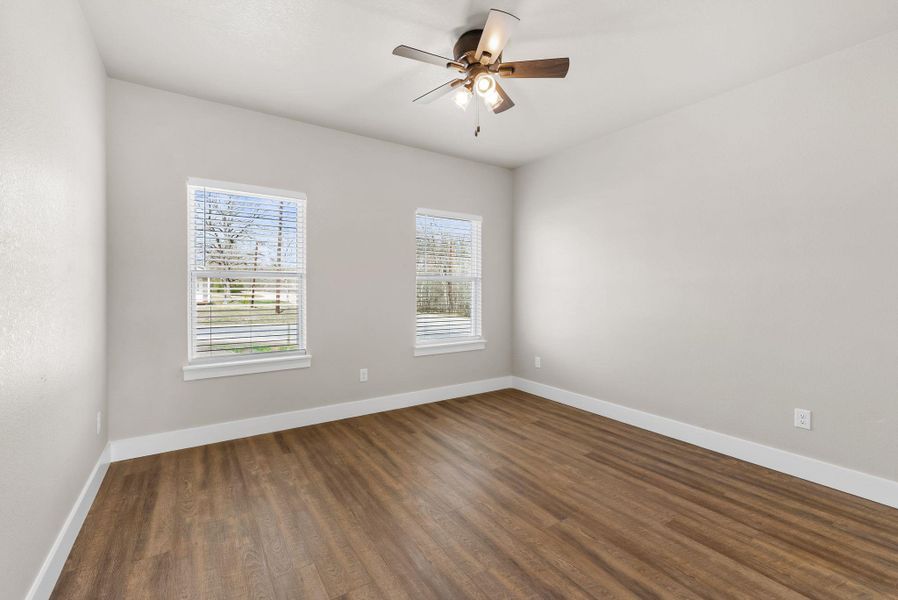Spare room with a ceiling fan and dark wood-type flooring