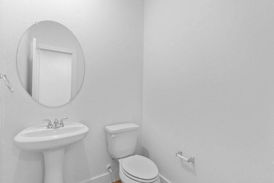 Convenient powder bath with pedestal sink and sleek fixtures, perfect for guests. Convenient powder bath with pedestal sink and sleek fixtures, perfect for guests.