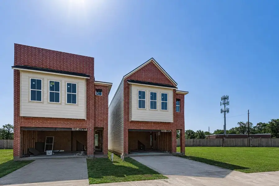 Contemporary new-construction exterior showcasing the home’s modern brick-and-siding elevation, clean architectural lines, upper-level windows, and attached garage. The open garage and visible framing reflect the active construction stage, while the wide driveway, green lawn, and bright blue sky help highlight the fresh, low-maintenance setting within the developing boutique community. Contemporary new-construction exterior showcasing the home’s modern brick-and-siding elevation, clean architectural lines, upper-level windows, and attached garage. The open garage and visible framing reflect the active construction stage, while the wide driveway, green lawn, and bright blue sky help highlight the fresh, low-maintenance setting within the developing boutique community.