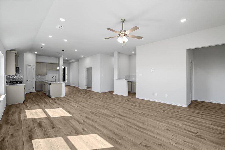 Unfurnished living room with light wood-type flooring, recessed lighting, and a ceiling fan Unfurnished living room with light wood-type flooring, recessed lighting, and a ceiling fan