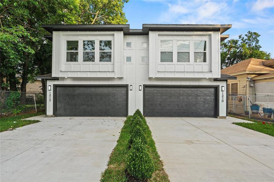 View of front facade featuring a garage, driveway, and board and batten siding View of front facade featuring a garage, driveway, and board and batten siding
