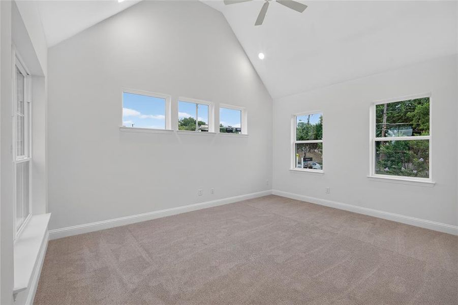 Vaulted ceiling room featuring light beige carpeting, multiple windows, recessed lighting, and a ceiling fan Vaulted ceiling room featuring light beige carpeting, multiple windows, recessed lighting, and a ceiling fan