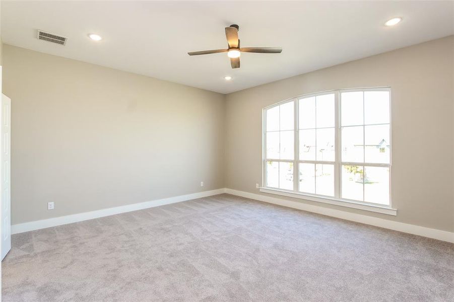 Carpeted empty room with ceiling fan