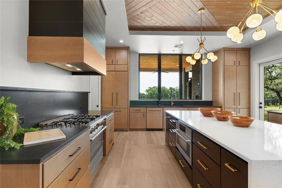 Kitchen featuring high end range, wood ceiling, premium range hood, light wood-style floors, and pendant lighting Kitchen featuring high end range, wood ceiling, premium range hood, light wood-style floors, and pendant lighting