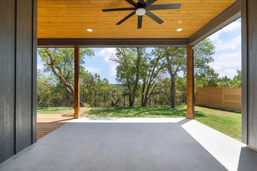 Fenced backyard featuring ceiling fan and a patio