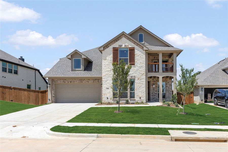 Two-story home with stone and brick exterior, two-car garage, and second-floor balcony Two-story home with stone and brick exterior, two-car garage, and second-floor balcony