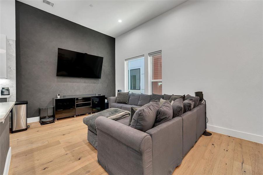 Living area with light wood finished floors and recessed lighting Living area with light wood finished floors and recessed lighting