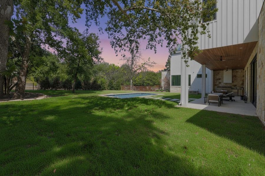 Yard at dusk featuring a patio, a yard, and an outdoor pool Yard at dusk featuring a patio, a yard, and an outdoor pool
