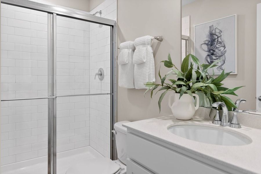 Walk-in shower with tile surround at primary bath Walk-in shower with tile surround at primary bath