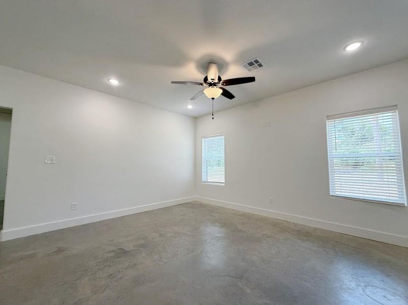 Unfurnished room with finished concrete flooring, a ceiling fan, and recessed lighting Unfurnished room with finished concrete flooring, a ceiling fan, and recessed lighting