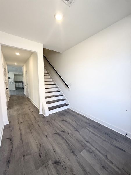 Stairs with recessed lighting and wood finished floors