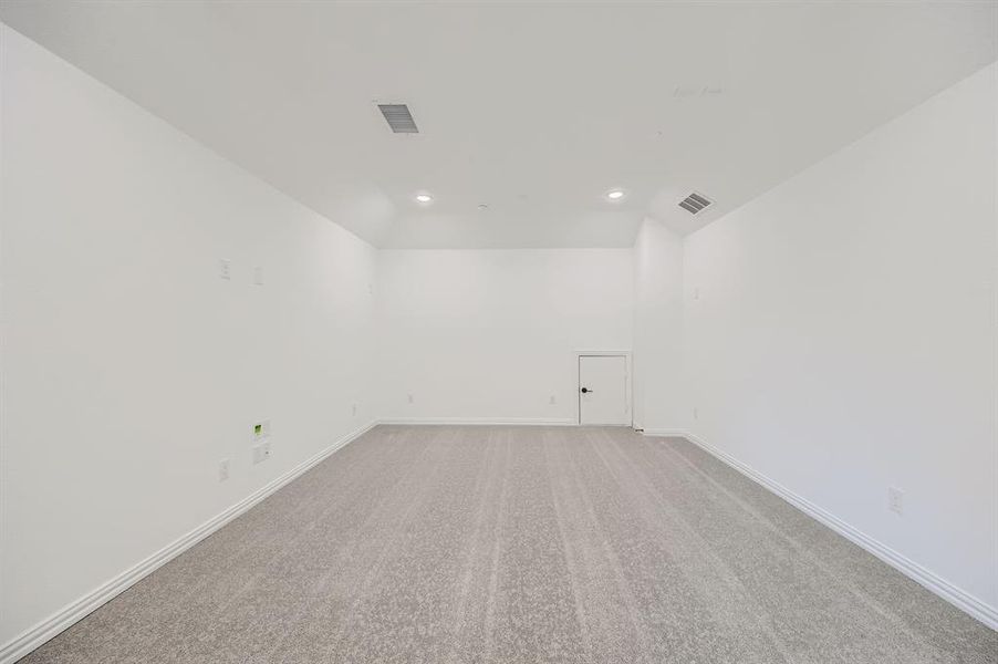 Carpeted empty room with lofted ceiling