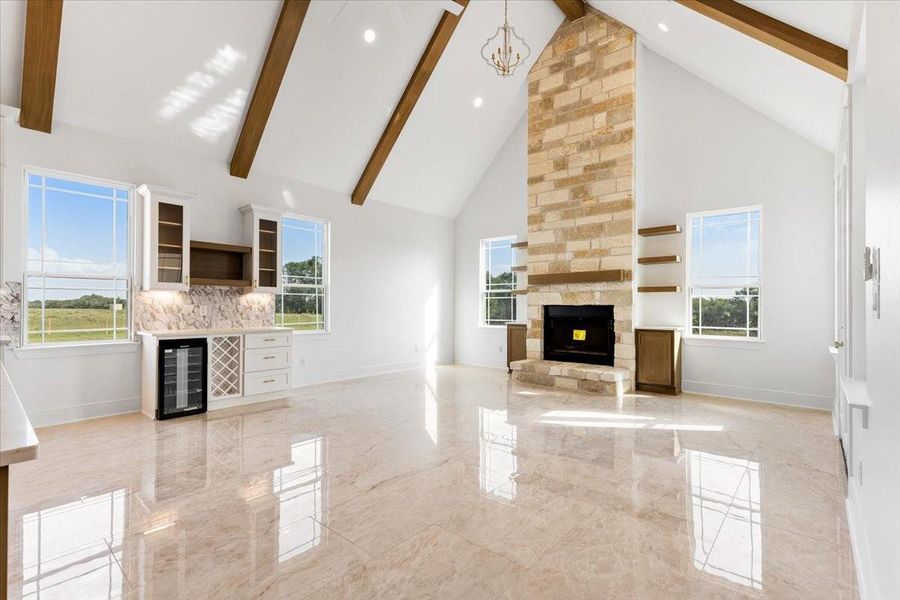 Alternative angle of the living room featuring the stone fireplace and decorative ceiling beams. Alternative angle of the living room featuring the stone fireplace and decorative ceiling beams.