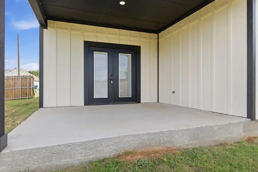 Doorway to property featuring board and batten siding, french doors, and a patio area Doorway to property featuring board and batten siding, french doors, and a patio area