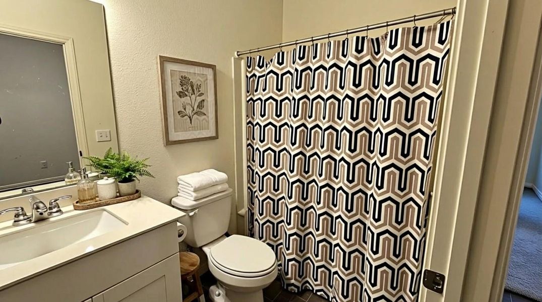 Bathroom with vanity, curtained shower, and a textured wall