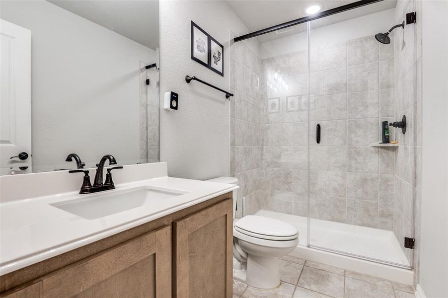 Bathroom with a shower stall, vanity, and tile patterned floors Bathroom with a shower stall, vanity, and tile patterned floors