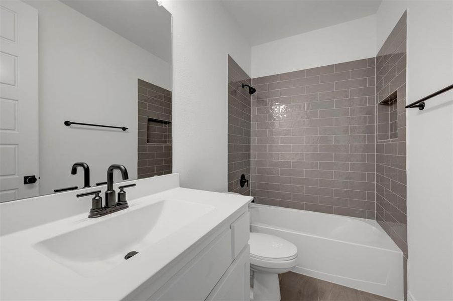 The bathroom features a vanity with an integrated sink and a black faucet, complemented by a mirror