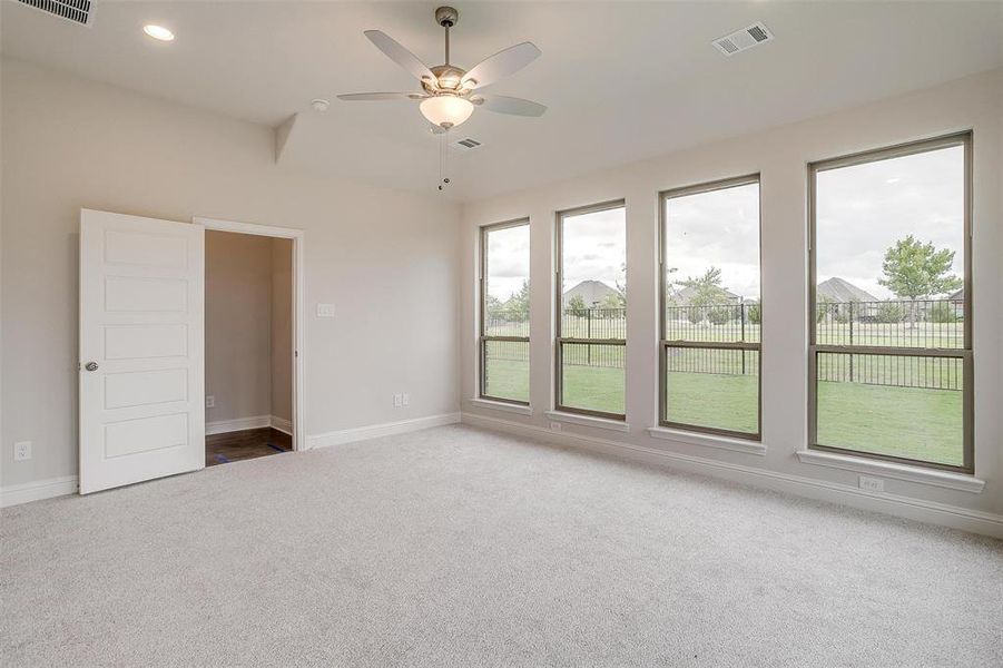 Carpeted spare room with ceiling fan