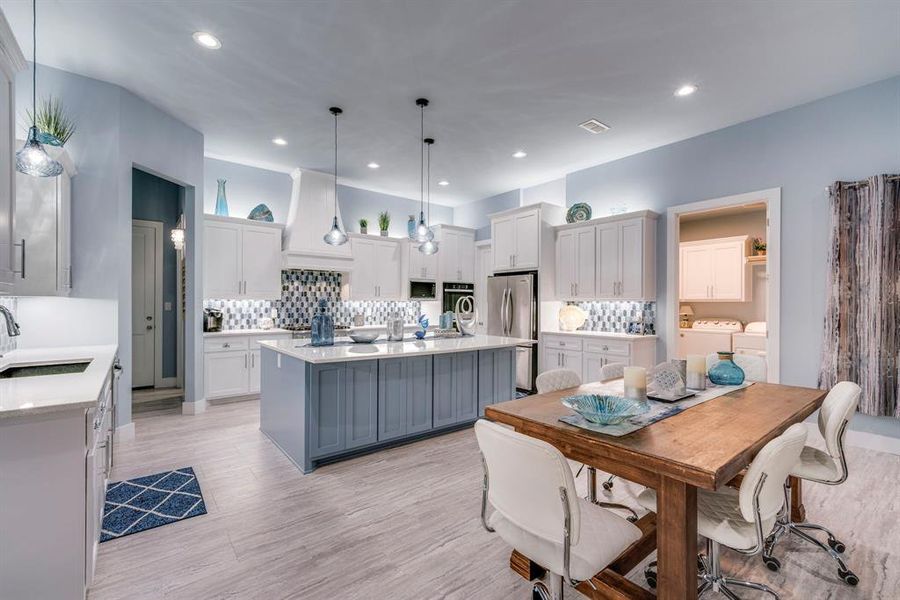 Kitchen featuring pendant lighting, backsplash, huge island with seating