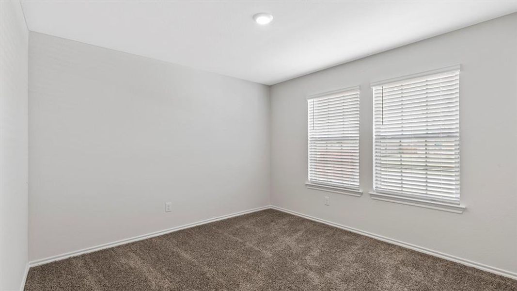 Unfurnished room featuring dark colored carpet and baseboards
