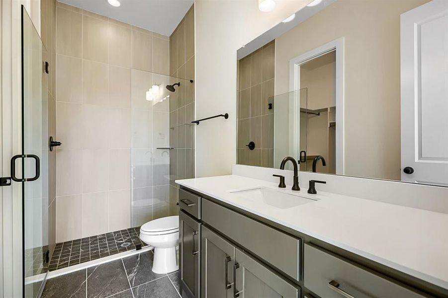 Full bath featuring vanity, a shower stall, and a spacious closet Full bath featuring vanity, a shower stall, and a spacious closet